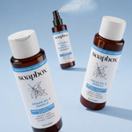 Soapbox anti-humidity flexible hold hairspray with spray nozzle shown between argan oil shampoo and conditioner bottles on bl
