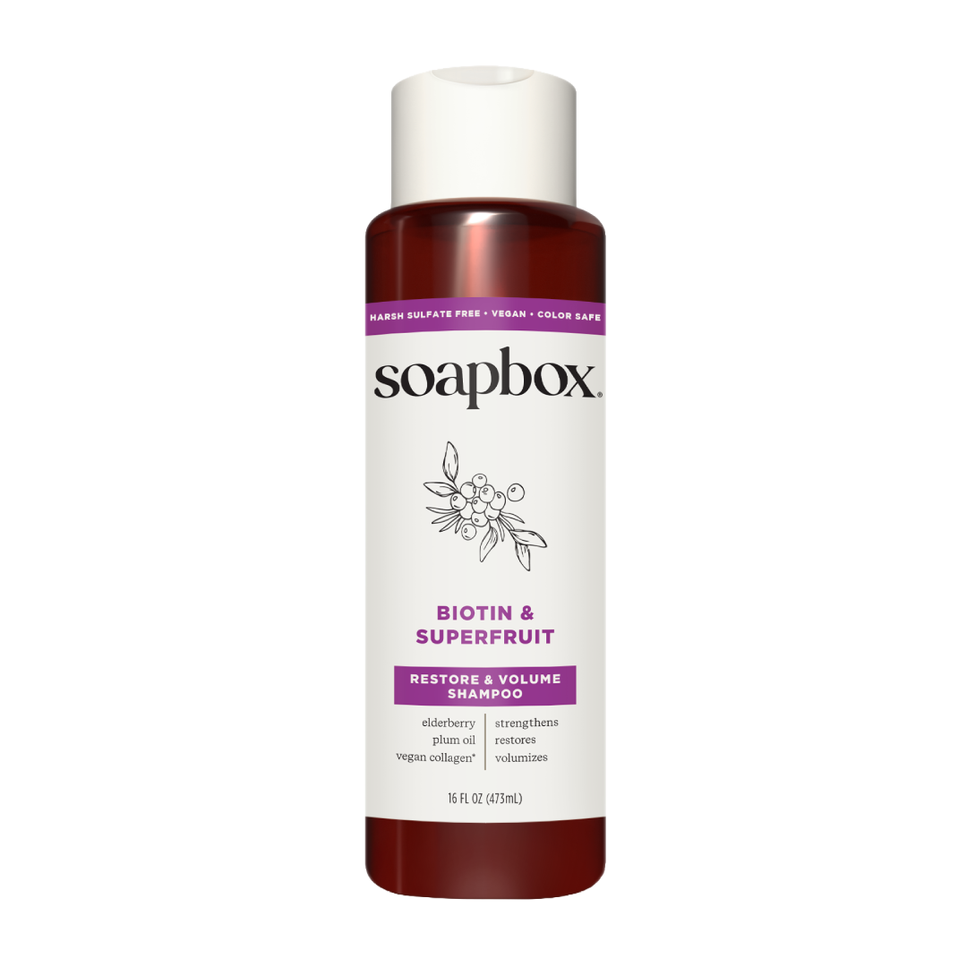 Soapbox Biotin & Superfruit Restore & Volume Shampoo bottle with white cap and burgundy liquid.