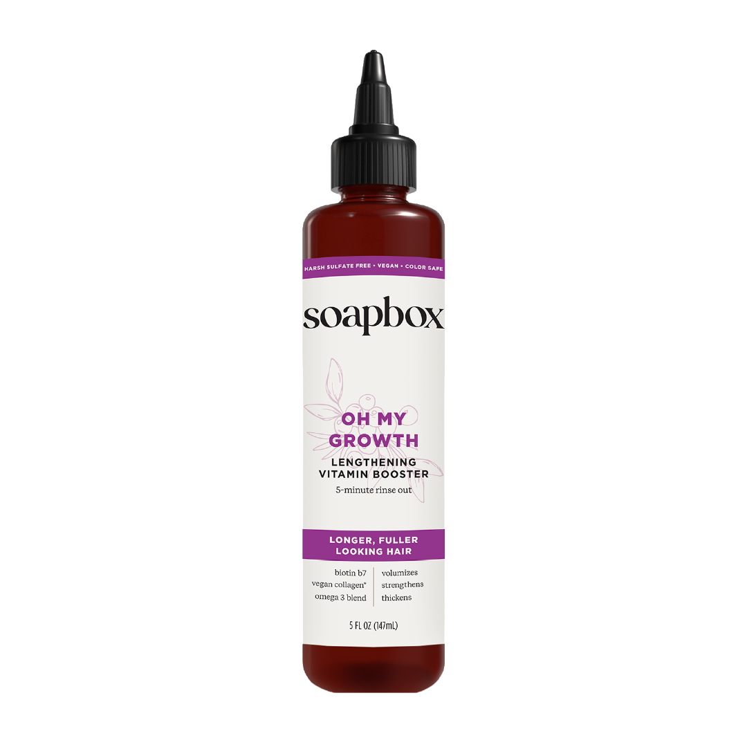 Soapbox Oh My Growth Lengthening Vitamin Booster in dark amber bottle with black pointed cap and purple label, 5 fl oz size.