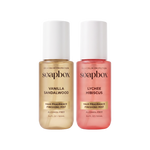 Two Soapbox hair finishing mist bottles: beige Vanilla Sandalwood and pink Lychee Hibiscus, each 3.4 fl oz, alcohol-free.