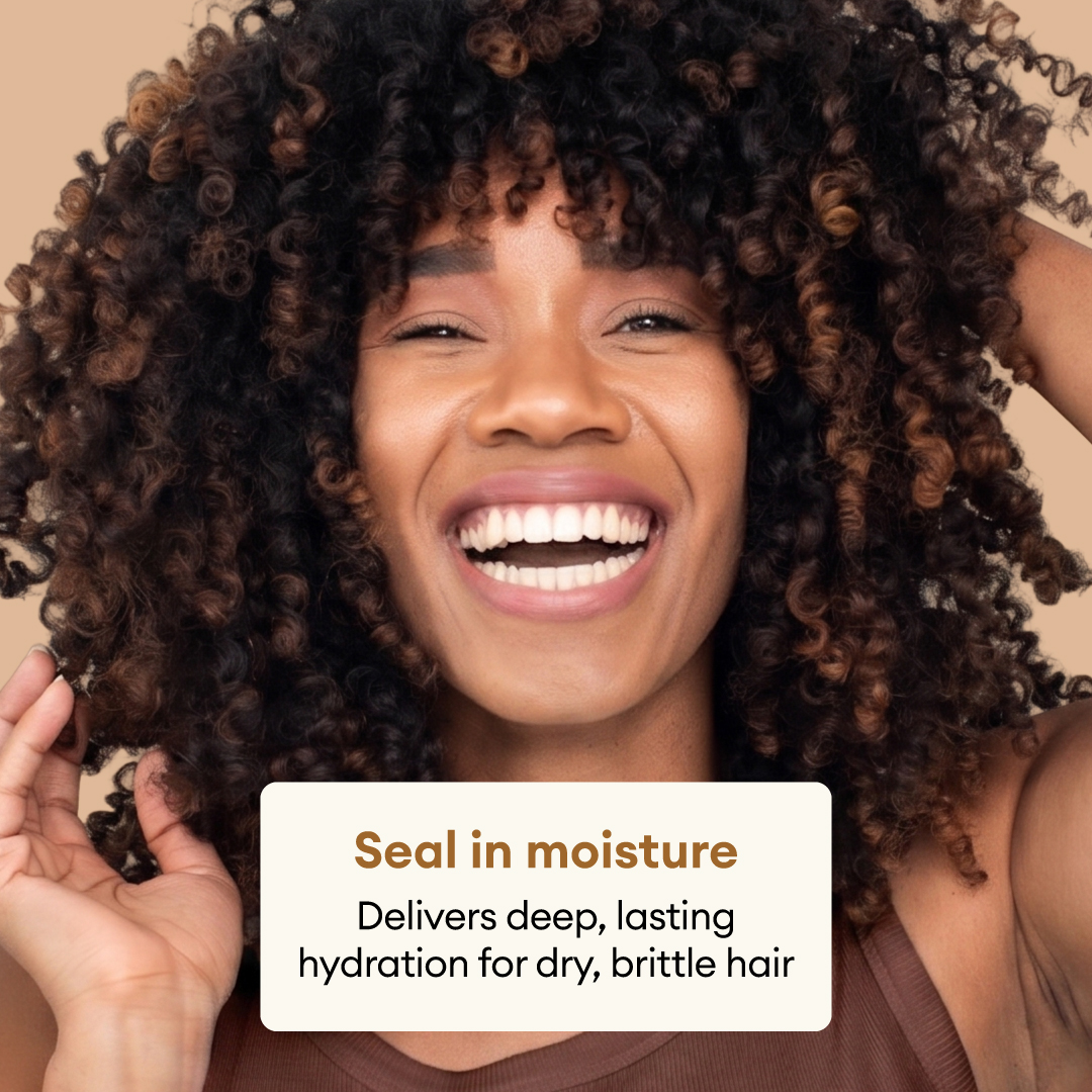 Person with dark curly hair with bronze tones smiling against a beige background.