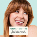 Person with copper-toned hair and bangs smiling against light blue background with product benefits text overlay.