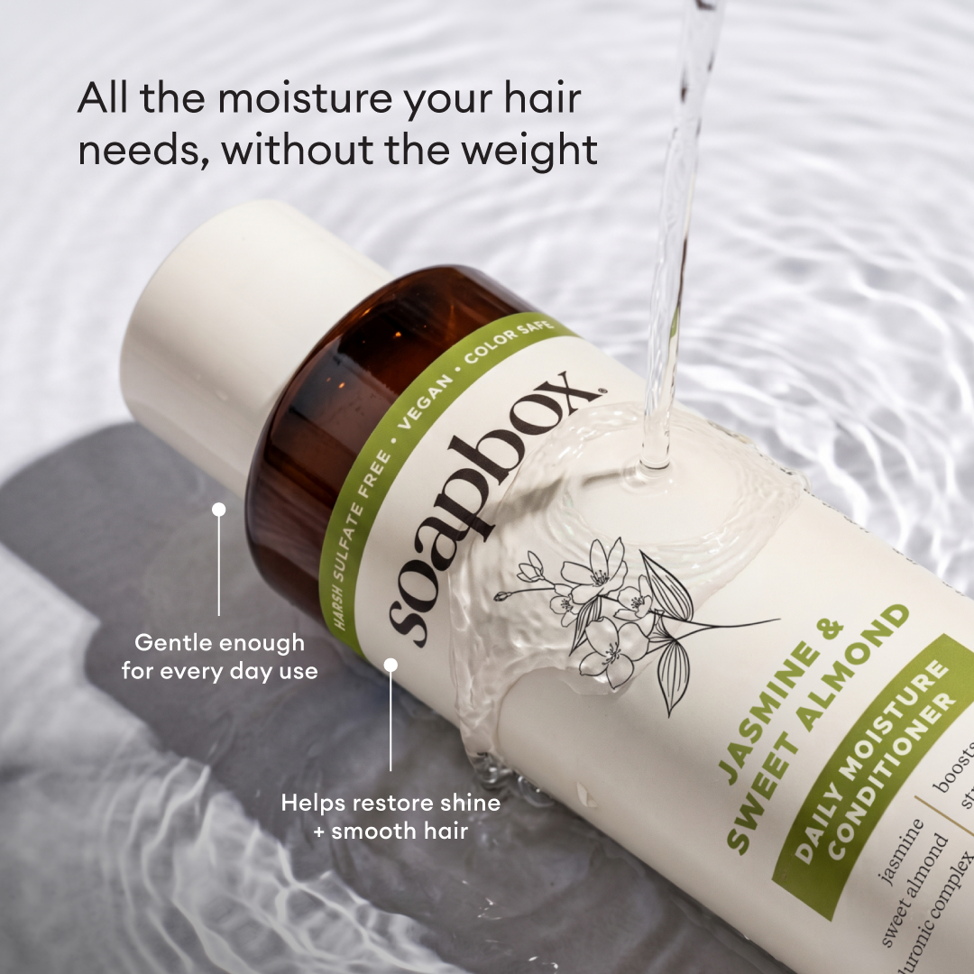 Soapbox Jasmine & Sweet Almond Daily Moisture Conditioner bottle with white cap on rippled water background.