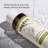 Cream-colored shampoo bottle with brown cap and green label featuring jasmine flower illustration, positioned on white fabric