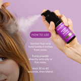 Hand holding purple dry shampoo bottle spraying white powder onto brown hair against lavender background.