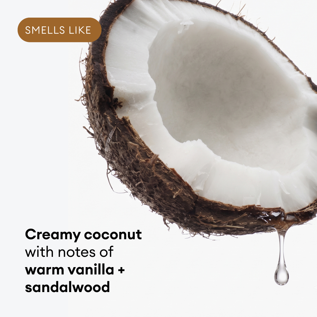 Halved coconut with white flesh and brown shell, liquid droplet hanging below.