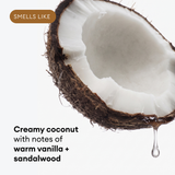 Halved coconut with white flesh and brown shell, liquid droplet hanging below.