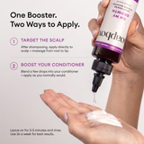 Hand holding dark purple bottle with dropper dispensing clear liquid onto palm with white cream.