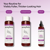 Three Soapbox hair care bottles: shampoo and conditioner with biotin and superfruit, plus Oh My Growth lengthening vitamin bo