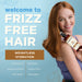 Woman with reddish-brown hair holding a brown and cream haircare bottle against a light blue background.