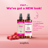 Two spray bottles of Shield & Shine heat protecting blowout spray with black caps on pink background surrounded by raspberrie
