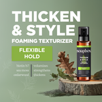 Soapbox foaming texturizer spray bottle with amber glass and black pump top on wooden platform with dried leaves.