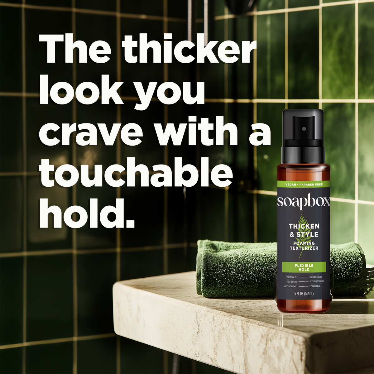 Soapbox Thicken & Style Foaming Texturizer spray bottle with amber glass and black pump top on marble surface.