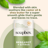 Soapbox aluminum-free deodorant stick in bergamot and citrus scent with green and white packaging, surrounded by fresh green 
