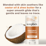 White and orange Soapbox deodorant stick with coconut + vanilla label next to a halved coconut.