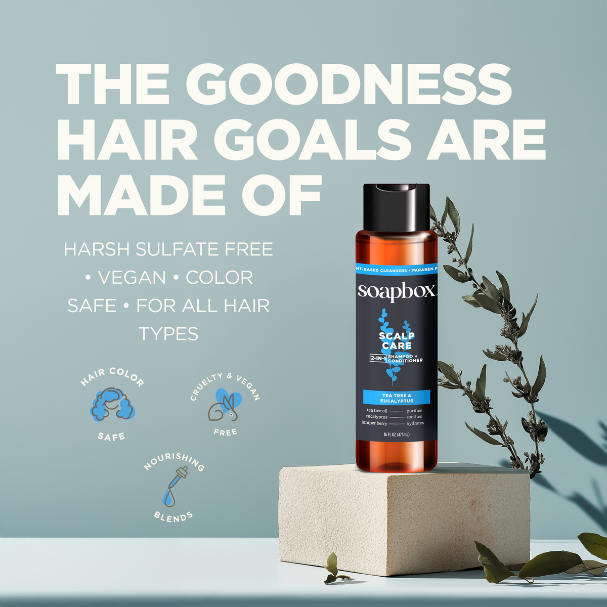 Soapbox scalp care shampoo and conditioner bottle with black cap displayed on cream pedestal with green botanical sprigs.