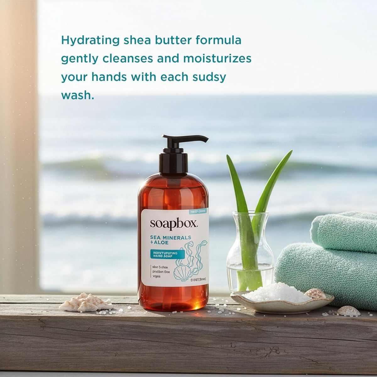 Soapbox liquid hand soap bottle with black pump dispenser next to aloe plant, folded towels, and seashells on wooden surface 