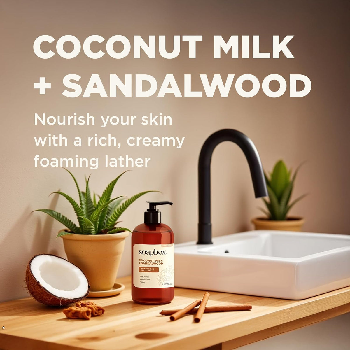Amber bottle of liquid hand soap with black pump dispenser on wooden countertop near sink and potted plants.