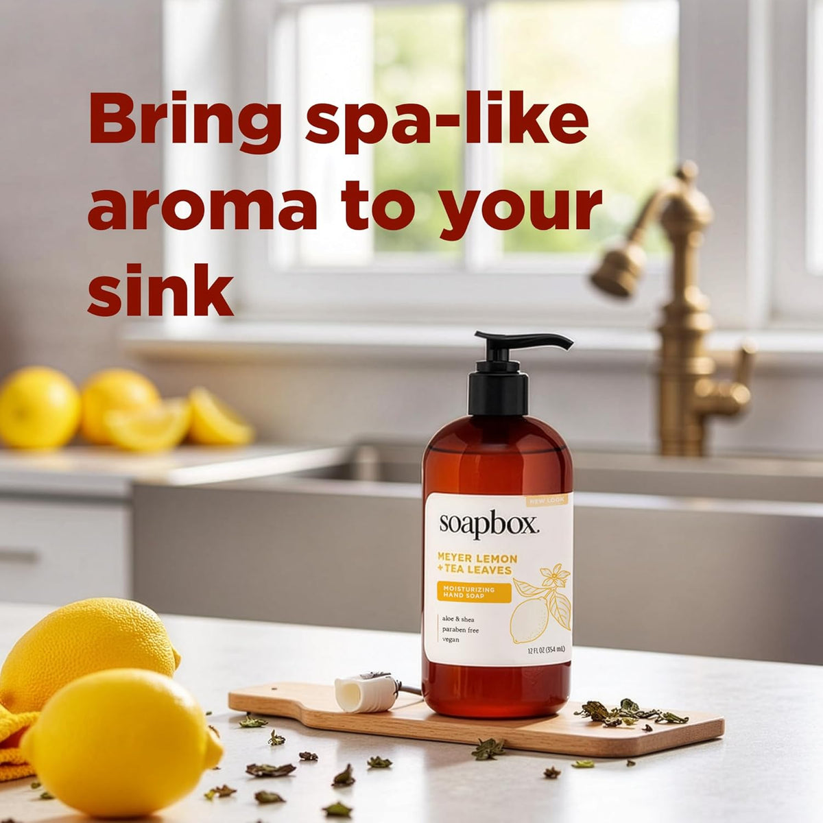 Amber glass pump bottle of Soapbox Meyer Lemon + Tea Leaves hand soap displayed on wooden board with fresh lemons and dried t