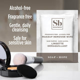 Soapbox fragrance-free makeup remover wipe packet displayed next to cosmetic brush and compact powder.