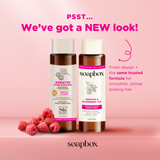 Two brown bottles with white caps on pink background surrounded by fresh raspberries, displaying keratin and raspberry seed o