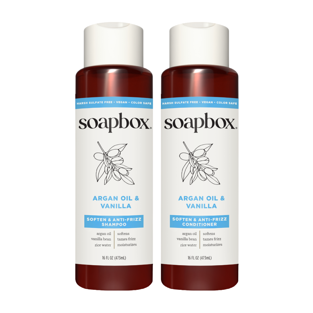 Two Soapbox bottles with cream caps and burgundy lower sections labeled "Argan Oil & Vanilla" shampoo and conditioner, 16 fl 