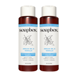 Two Soapbox bottles with cream caps and burgundy lower sections labeled "Argan Oil & Vanilla" shampoo and conditioner, 16 fl 