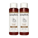 Two Soapbox bottles with white caps and dark red lower sections labeled Coconut & Shea Deep Moisture Shampoo and Conditioner,