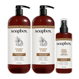 Three Soapbox haircare bottles: two large pump bottles of Coconut & Shea Deep Moisture Shampoo and Conditioner, and one spray