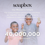 Two children holding soap bars with Soapbox company mission text on lavender background.