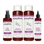 Four Soapbox haircare products in dark amber bottles with white labels: volumizer spray, two shampoo bottles, and a lengtheni
