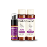 Three Soapbox haircare products: dry shampoo spray, shampoo, and conditioner in amber bottles with purple labels.