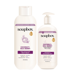 Two cream-colored Soapbox bottles: a body wash with flip cap on left and a pump lotion bottle on right, both labeled Coconut 