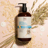 Brown pump bottle of body lotion surrounded by oat flakes, almond pieces, dried wheat stalks, and white cream dollops on pink