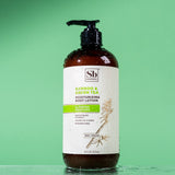 Brown bottle with black pump dispenser labeled "Bamboo & Green Tea Moisturizing Body Lotion" by Soapbox on mint green backgro